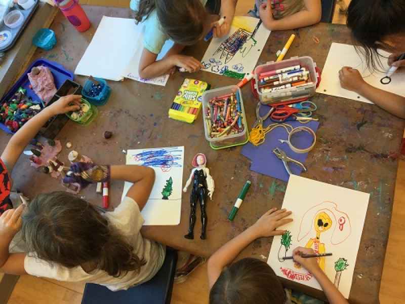 school-agers colouring at a table